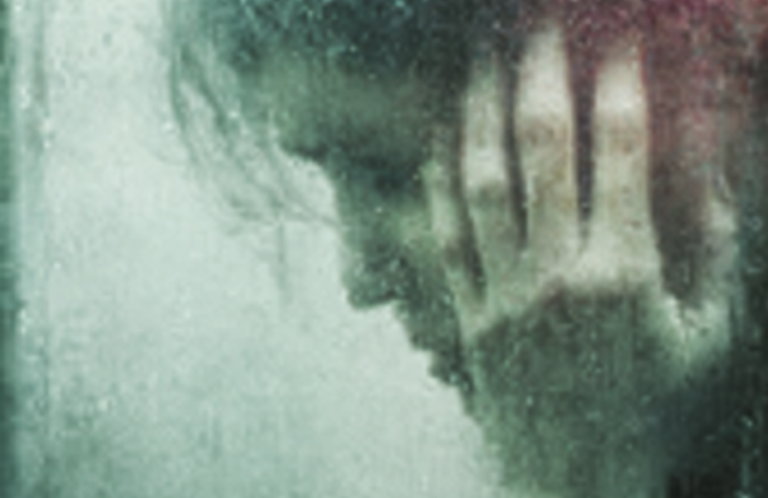 A person with their hand on their head, appearing distressed behind a foggy glass.